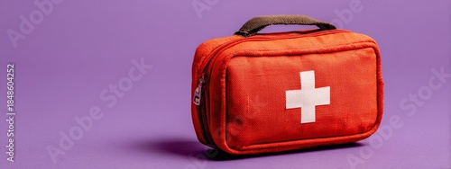 a small, square patterned object with a red cross design is prominently displayed in the foreground against a purple background, suggesting it could be an item of significance