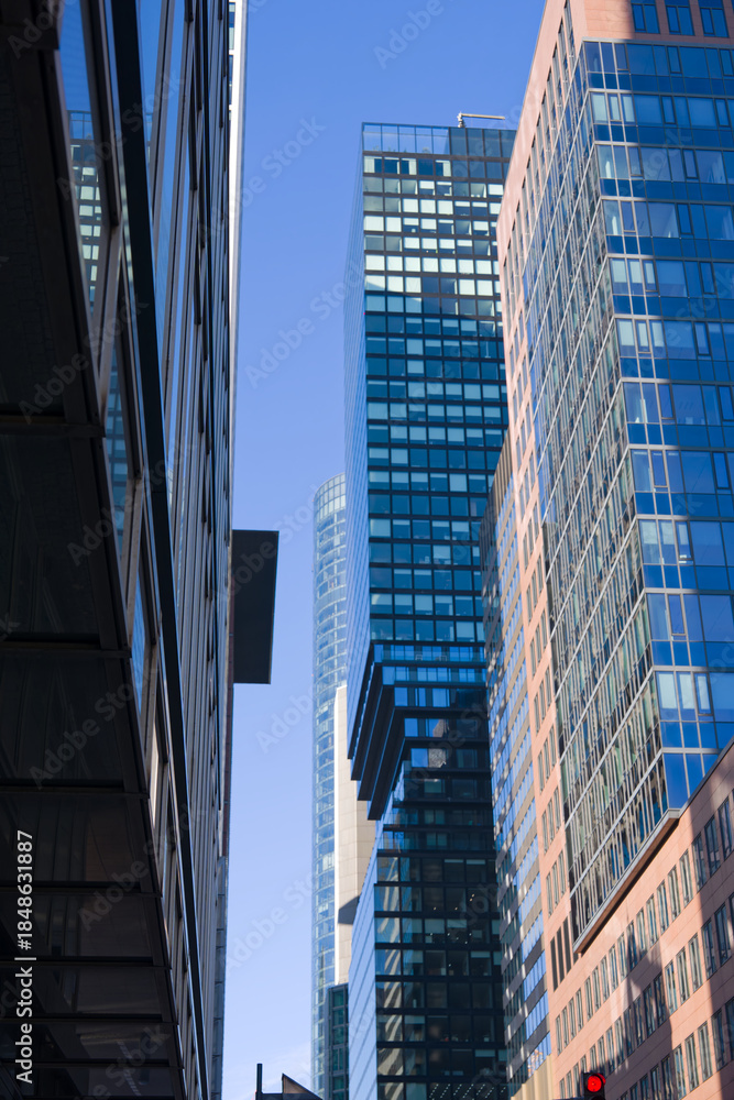 Naklejka premium Looking up modern skyscrapers at financial district at German city of Frankfurt on a sunny autumn day. Photo taken November 22nd, 2025, Frankfurt am Main, Germany.