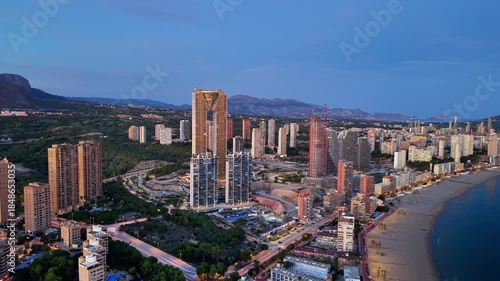 Twilight Coastal Skyline With Cranes Visible Above New Towers, Beach Curve And Illuminated Streets Great