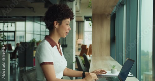 black woman customer success specialist celebrating video call at laptop