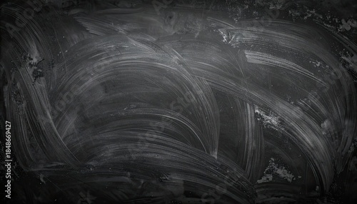 Dark, textured background featuring swirling white chalk erasure marks on a black slate surface.