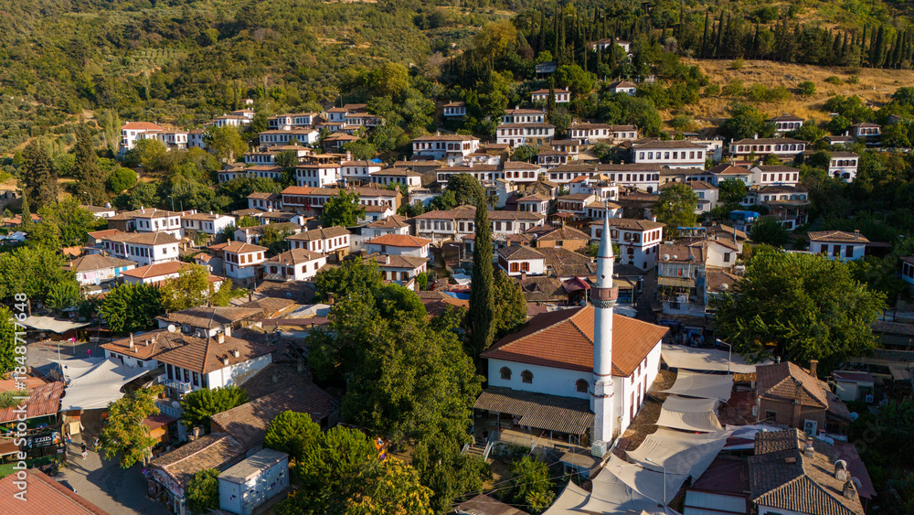 Obraz premium Aerial view of Sirince village in Turkey with traditional houses and mosque surrounded by green hills. Historic rural settlement, cultural heritage and popular travel destination.