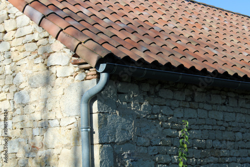 Toiture en tuiles canal ou romane, gouttière en zinc gris	