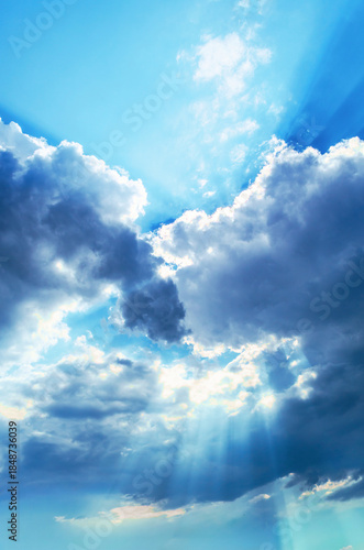 Canvas Print Sunbeams breaking through dramatic clouds on a bright blue sky