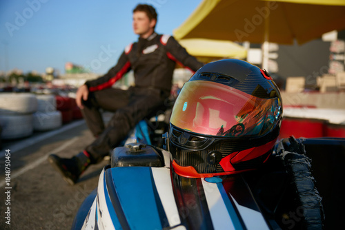 Tableau sur toile A racer poses confidently next to a gokart