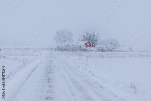 Farm barn and house in a cold winter landscape with snow and frost