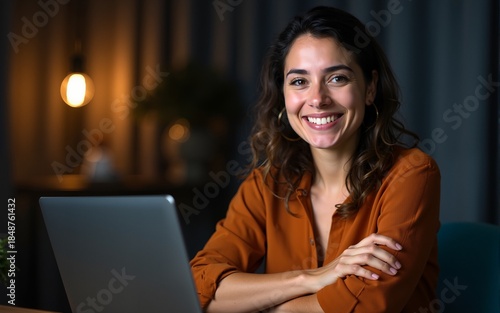 Middle age hispanic woman working using computer laptop at night happy face smiling with crossed arms looking at the camera. positive person. High quality