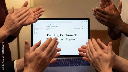 Brainstorming nonprofit grant approval funding celebration laptop screen with diverse hands clapping warm indoor setting showing appreciation