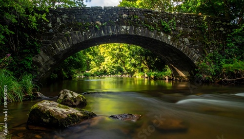 Stone arch bridge over a river surrounded by lush green trees