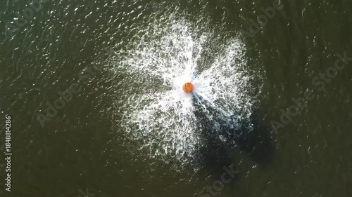 Aerial view of water aerators creating circular splashes on a green water surface. Abstract pattern representing water treatment, environmental management, sustainability, and clean water concepts.