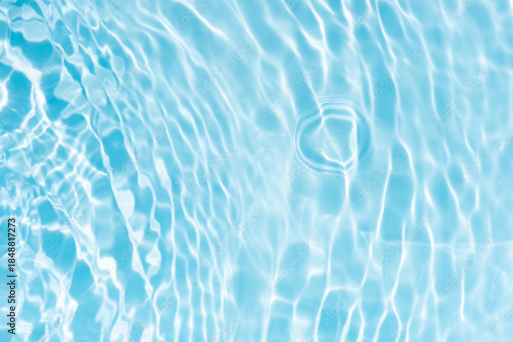 Obraz premium Blue water with ripples on the surface. Defocus blurred transparent blue colored clear calm water surface texture with splashes and bubbles. Water waves with shining pattern texture background.