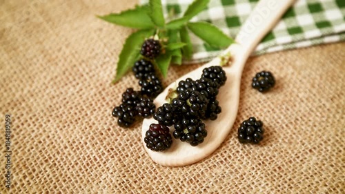 Fresh blackberries on wooden spoon and burlap