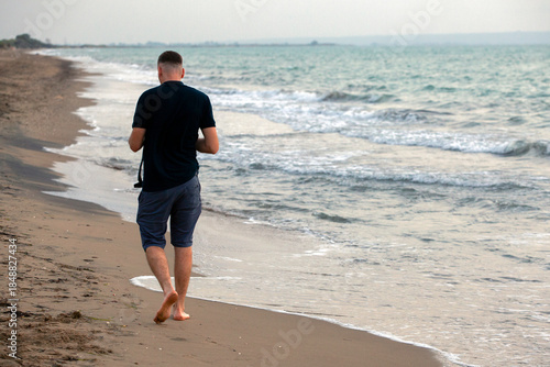 back view of a man walking on the beach