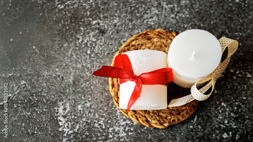 Wallpaper Mural White decorative candles with red and beige ribbons on a rustic mat, top view on dark textured background. Cozy minimalist holiday decor, romantic and relaxing atmosphere Torontodigital.ca