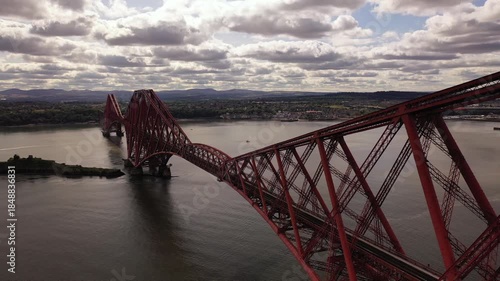 Aerial view of the striking red Forth Bridge spans the Firth of Forth, connecting the banks with its intricate steel structure, Inverkeithing, Scotland, United Kingdom.
