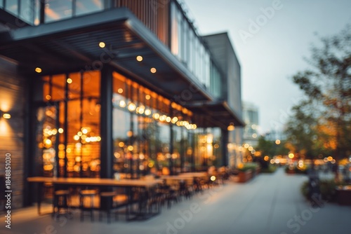 Exterior view of a modern establishment with warm interior lighting showcasing an outdoor seating area at dusk