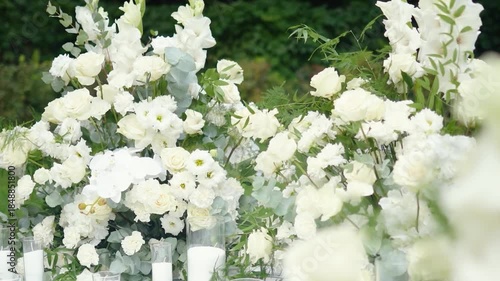 wedding arch of white rose flowers on the nature before the wedding ceremony of the bride and groom, festive romantic decor