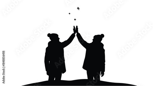 Two friends silhouetted giving each other a joyful high five in the snow