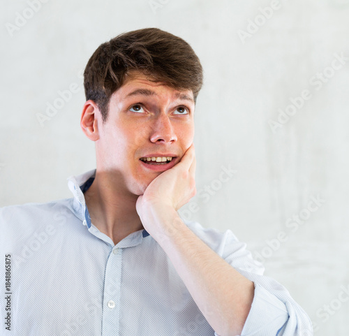 Unhappy man having a toothache in living room