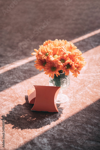 Blank Wedding Favor Box Mockup with Orange Flowers and Natural Sunlight Shadow