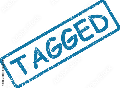 Clear blue rubber stamp impression vividly displays the word TAGGED on a clean white background