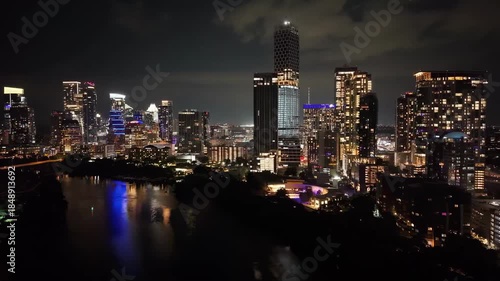 Nightscape of Austin's downtown with glowing skyscrapers, city lights, and river reflections. Urban and cityscape concepts