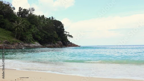 Close up of waves gently breaking onto a sandy beach.