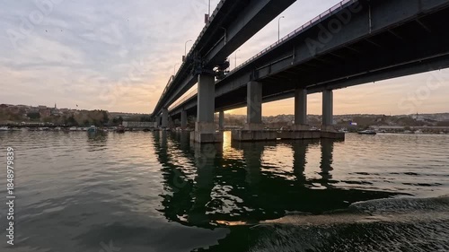Passing under The Golden Horn Bridge in a boat in Istanbul at a beautiful sunset
