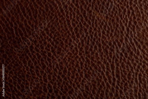Texture of dark brown leather shows fine details and depth in natural grain pattern
