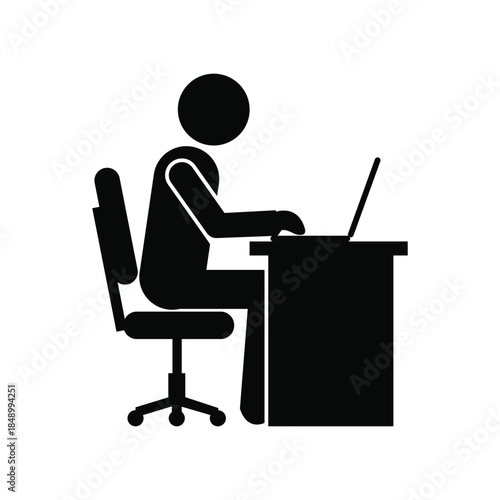 Silhouette of a Person Working on a Laptop at a Desk