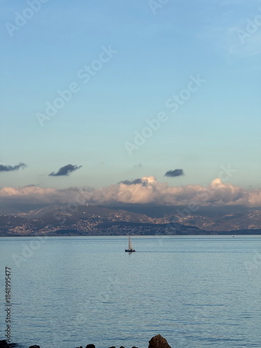 Minimalist ocean scenery with a single sailboat surrounded by gentle light and quiet space. The tranquil composition symbolizes simplicity, emotional clarity, and slow living, perfect for relaxation 