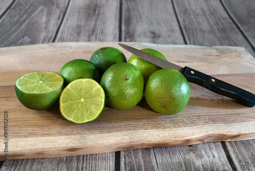 citrons vert avec découpe sur planche en bois