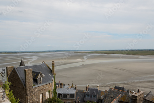 low tide sandy bay around medieval abbey  Mont Saint-Michelon tidal island in Normandy France. popular landmark attraction destination for cultural excursion