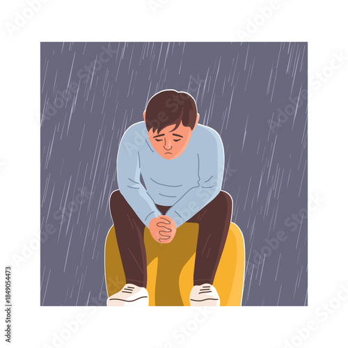 Sad teenage boy sitting alone in room