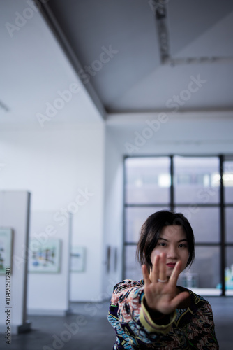 Young Woman Reaching Toward Camera in Modern Art Gallery