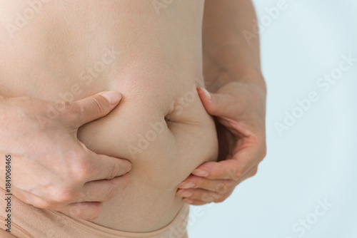 woman squeezes her belly fat
