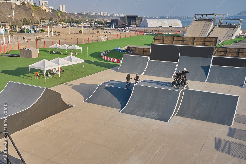 Fototapeta premium Bmx riders exercising and practicing freestyle tricks in a large outdoor urban skatepark