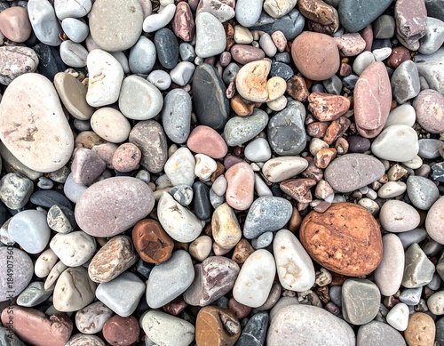 Assorted smooth beach rocks in varying sizes and colors. An overhead view