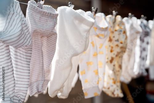 Baby clothes hanging on a clothesline in natural light