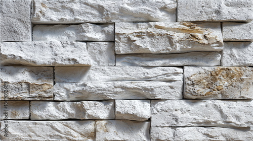 A close-up view of a detailed stone wall with textured layers and various shades and shapes. The wall's rugged surface evokes a sense of solidity and history, hinting at the passage of time