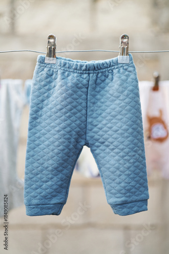 Quilted infant pants hanging in natural light