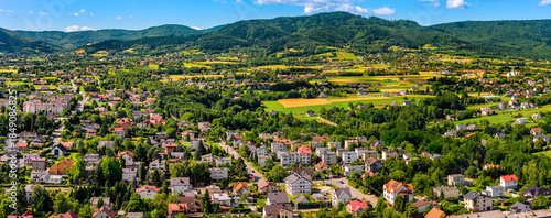 Aerial panoramic view of disperse housing of residential district of Andrychow city along railway track with Beskidy Mountains in background in Lesser Poland