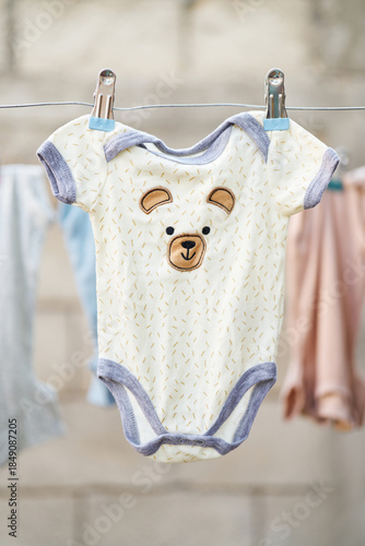 Baby bodysuit with bear design hanging