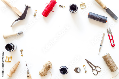 Frame flat lay of leather craftsman or shoemaker tools and equipment, top view