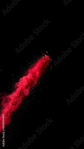 Title: Vibrant red powder explosion bursting against black background