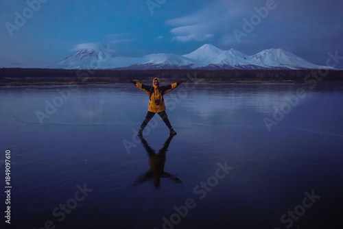 A Man on a Frozen Lake with a View of Kamchatka Volcanoes