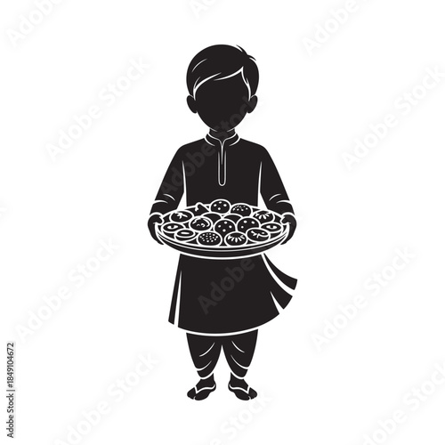A silhouette of a boy holding a platter of round sweets or treats