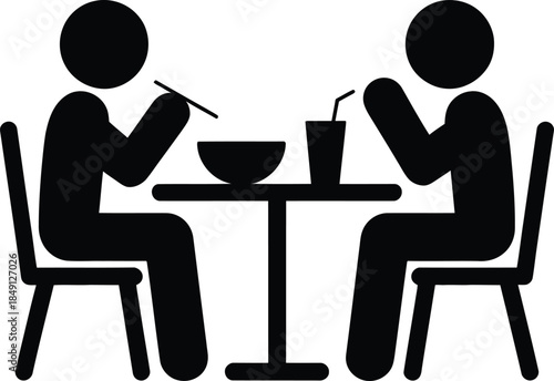 Two people sitting at a table and eating food
