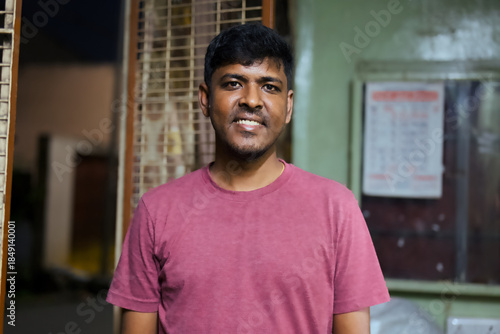Young man smiling in indoor setting at night