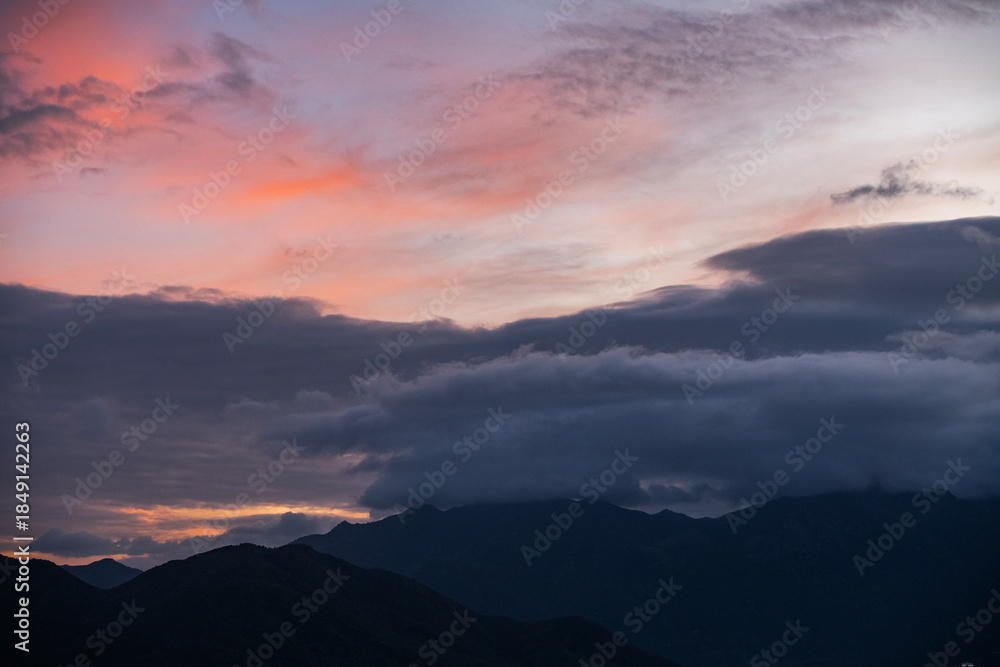 Fototapeta premium Dramatic sunset clouds after storm over the silhouette mountains .